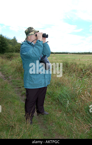 Vogelbeobachter Blick über ein Feld durch ein Fernglas Stockfoto