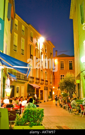 Französisches Restaurant überfüllt Terrassen, Fussgängerzone Szene Perpignan südlich von Frankreich in Old Town Center, Straßenlaternen in der Nacht Stockfoto