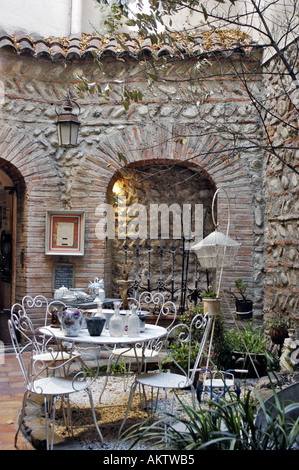 Gemauerte Wand, Perpignan Frankreich, kleine Antiquitäten Shop und "Salon du die" Tea Room im Zentrum der alten Stadt, Garten Stockfoto