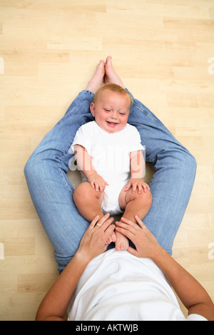 Baby Mütter Beine lächelnd Handauflegen Stockfoto