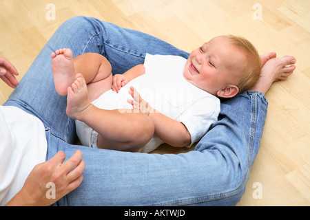 Baby Mütter Beine lächelnd Handauflegen Stockfoto