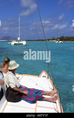 Mann sitzt auf dem Deck eines Katamarans Stockfoto