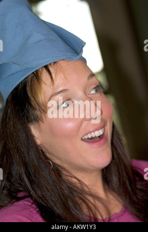 Frau Alter 32, die Spaß am Familienessen mit blauen Serviette Hut. Shakopee Minnesota MN USA Stockfoto