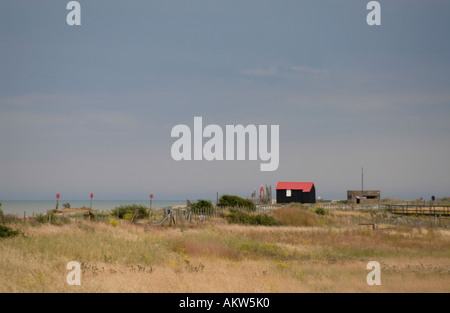 Überdachte rot und schwarz Wellblech Hütte und konkrete Zweiter Weltkrieg bunker auf die Schindel oberhalb der Mündung des Flusses Rother Stockfoto