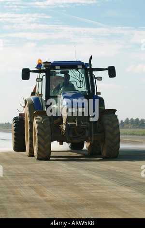 Traktor Besprühen mit Wasser um den Staub auf einer neuen Umgehungsstraße zu halten, Stockfoto