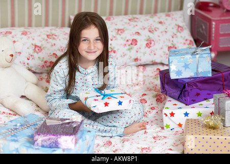 Mädchen sitzen im Bett halten, Weihnachtsgeschenke, Porträt Stockfoto