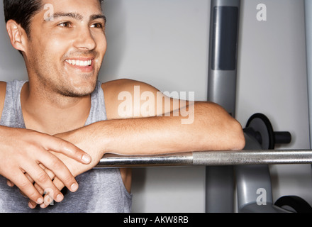 Verschwitzten Mann ruht auf Langhantel nach Training Stockfoto