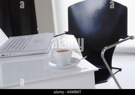 Laptop mit Kaffeetasse im Vordergrund Stockfoto