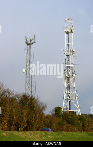 Sehr große Mobilfunkmasten neben einer Straße, Zwerg einem vorbeifahrenden Auto. Stockfoto