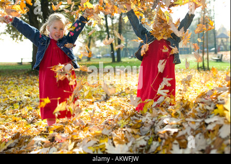Zwillinge spielen mit Herbst Blätter, close-up Stockfoto