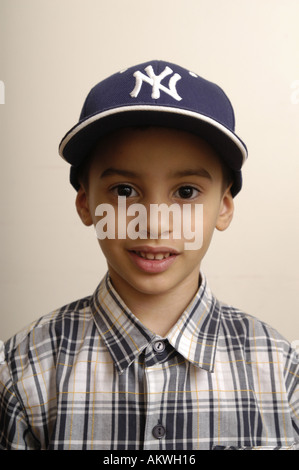 Ein Portrait eines jungen Latino Kleinkindes trägt ein kariertes Hemd und New York Yankees Baseball-Kappe. Stockfoto