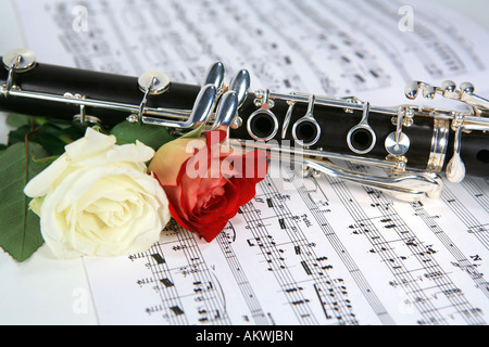 B-Klarinette mit einer roten und einer weißen Rose zu den Noten Stockfoto