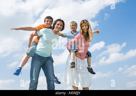 Huckepack-Eltern Carryig Söhne Stockfoto