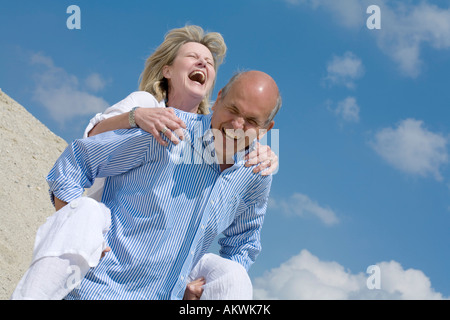 Älteres Paar, Mann mit Frau Huckepack Stockfoto