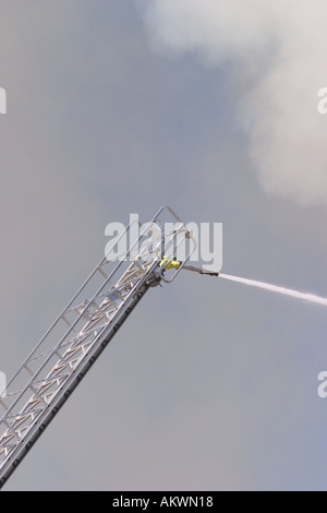 Wasser gesprüht auf einem großen industriellen Feuer von einer Boom-Leiter Stockfoto