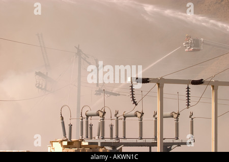 Wasser gesprüht auf einem großen industriellen Feuer durch ein Feuerwehrmann von einem Schnorchel-boom Stockfoto