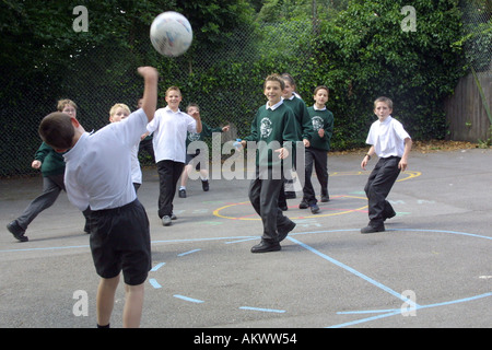 Jungs spielen Fußball im Dorf Grundschule Spielplatz Stockfoto