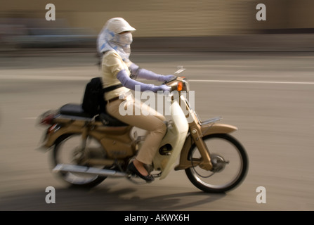 Modebewusste junge Frau auf Beschleunigung Motorrad im Mekong-Fluss-Delta südlich von Saigon Stockfoto