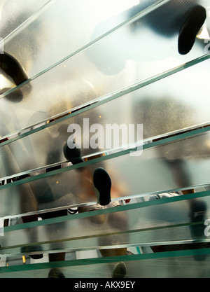 Menschen, die transparente Treppe hinauf klettern. Stockfoto
