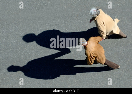 Seniorenpaar, die Hand in Hand gehen, Vogelperspektive mit Schatten Stockfoto