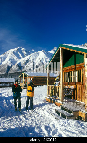 Zwei weibliche Langläufer vor Blockhütten Talkeetna Berge Sheep Mountain Lodge Alaska Herr Stockfoto