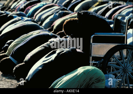 PALÄSTINENSER MANN IM ROLLSTUHL BÖGEN ZUM MEKKA MUSLIMISCHEN GEBET ZU BETEN Stockfoto