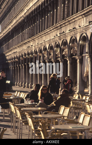 VENEDIG, ITALIEN. Die Menschen Sie genießen die Wintersonne und trinken "al Fresco" in einem Café an der Piazza San Marco. Stockfoto