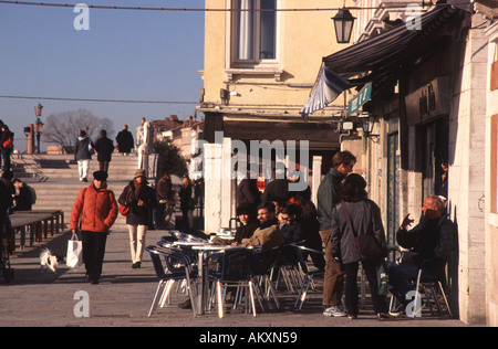 VENEDIG, ITALIEN. Menschen genießen die Wintersonne entlang der Canale Delle Giudecca Stockfoto
