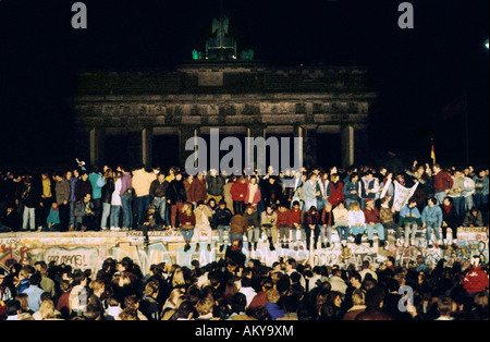 Fall der Berliner Mauer: Menschen aus Ost und West-Berliner Klettern an der Wand am Brandenburger Tor am 9. November 1989, werden Stockfoto