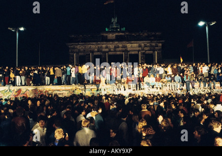 Fall der Berliner Mauer: Menschen aus Ost und West-Berliner Klettern an der Wand am Brandenburger Tor am 9. November 1989, werden Stockfoto