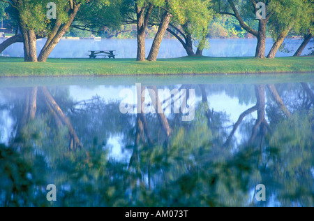 Picknick-Tisch spiegelt sich in einem See Stockfoto