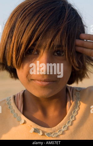 Ein junges Mädchen posiert für ein Porträt bei Sonnenuntergang in den Dünen von großen Thar Wüste außerhalb von Manvar Rajasthan Indien Stockfoto