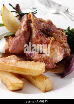 Ein ganzes gebratenes Poussin mit Spielchips und roten Zwiebeln redaktionelle Delikatessen Stockfoto