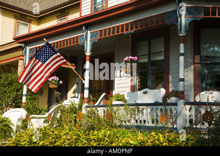 ILLINOIS Galena weißen Korbsesseln auf Veranda des viktorianischen Haus amerikanische Flagge hängen Blumenkorb Stockfoto