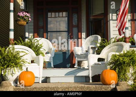 ILLINOIS Galena weißen Korbsesseln auf Veranda des viktorianischen Haus amerikanische Flaggen Topfpflanzen Farne hängen Blumenkorb Stockfoto