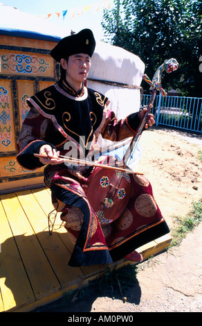 Mongolei Asien Ulaanbaatar Khumii Kehle Sänger in traditioneller Tracht mit Morin Khuur Pferdekopf-Geige vor Jurte sitzen Stockfoto