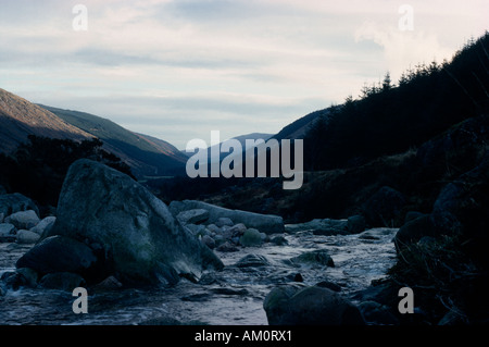 Irland Co Wicklow Glenmalure Tal Wicklow Mountains im Winter mit Felsen im Fluss im Vordergrund unter feinen Decke von Schnee Stockfoto