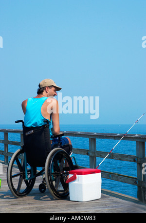 Mann im Rollstuhl angeln und einen sonnigen Tag am Wasser in Chesapeake Bay, Virginia genießen. USA Stockfoto