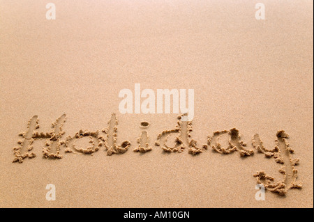 Das Wort Urlaub geschrieben im Sand am Strand Stockfoto