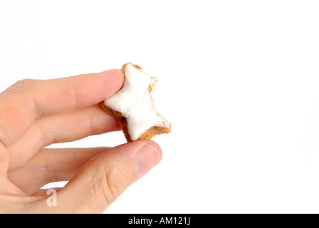 Hand hält in Zimt aromatisiert sternförmige Keks gebissen Stockfoto