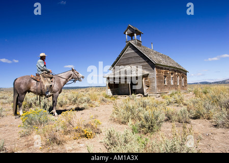 Cowboy auf Pferd im alten Schulhaus, Wildwest, Oregon, USA Stockfoto