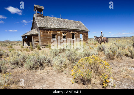 Cowboy auf Pferd im alten Schulhaus, Wildwest, Oregon, USA Stockfoto