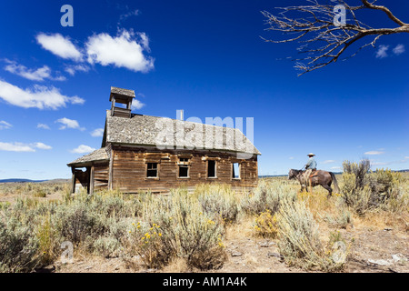 Cowboy auf Pferd im alten Schulhaus, Wildwest, Oregon, USA Stockfoto