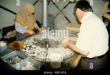 Seidenraupe-Arbeitnehmer, die mit der Kokons und feine Fäden in den Entscheidungsprozess Seide Stockfoto