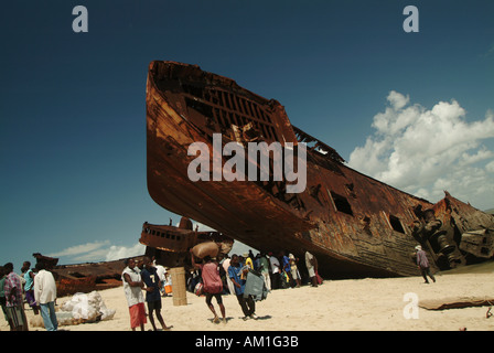 Menschen stehen am Strand durch das Schiff Friedhof und Rost Tanker am Strand in Beira. Mosambik, Südafrika Stockfoto