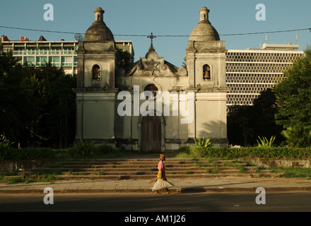 Eine afrikanische Frau geht vorbei an einem verlassenen portugiesischen Kathedrale in Quelimane Stadt. Mosambik, Südafrika Stockfoto