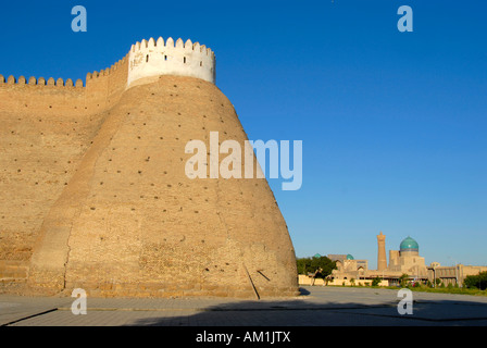 Turm und Mauer der Festung Ark mit Minarett Kalon im Hintergrund Buchara Usbekistan Stockfoto