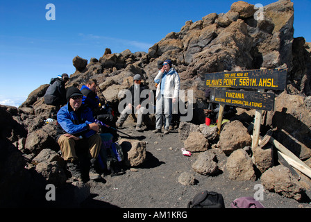 Erfolgreiche Gruppe von Bergsteigern am Schild auf dem Gipfel Gilman es Point (5681 m) Kraterrand Kilimanjaro Tanzania Stockfoto