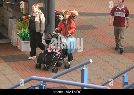 Mutter, Großmutter und Zwillingstöchtern im Doppel Kinderwagen in Burnley Einkaufszentrum Lancashire Stockfoto