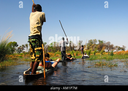 Einheimische im Mokoro Dugoutboat auf einen touristischen Ausflug in das Okavango Delta, Botswana Stockfoto